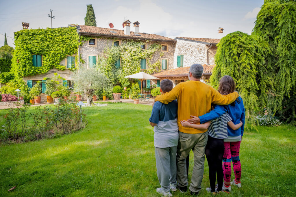 Abbildung: Familie steht beeindruckt vor einem italienischen Haus mit Landhaus-Flair