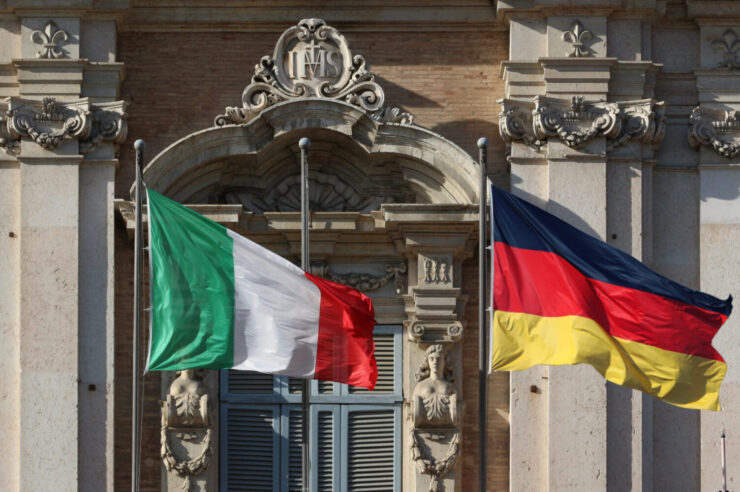 Abbildung: Deutsche und italienische Flagge vor klassizistischem Gerichtsgebäude